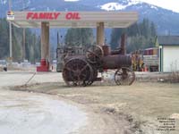 Old tractor displayed at Family Oil gas station.