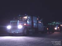 A Kenworth truck tows a Greyhound bus.